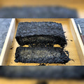 Golden Flower Fu Tea Brick opened on a wooden tray showing dark tea and golden flecks